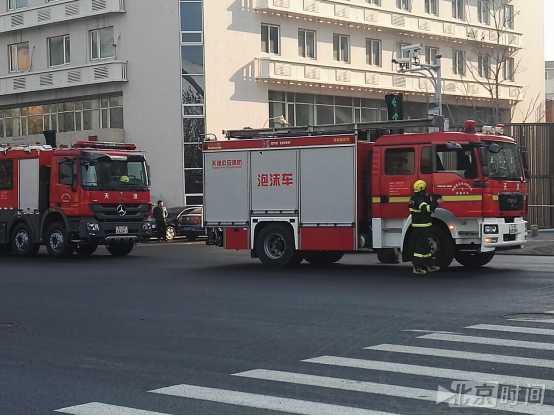 失火的大厦楼下停着两辆消防车(记者王涛 拍摄)