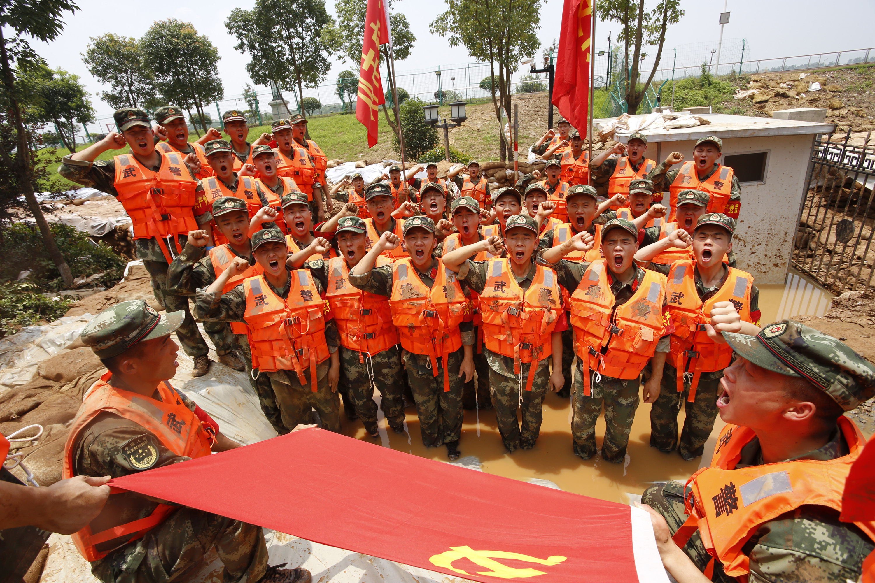 _2016年6月下旬,受持续强降雨影响,江苏省多地接连出现险情。这是武警江苏总队官兵在抗洪抢险任务中组织开展火线入党时的场景。徐宜佳摄