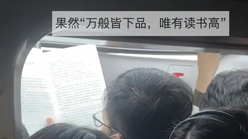 早高峰地铁上,男孩在拥挤的车厢中旁若无人地看书 早高峰地铁上,男孩在拥挤的车厢中旁若无人地看书