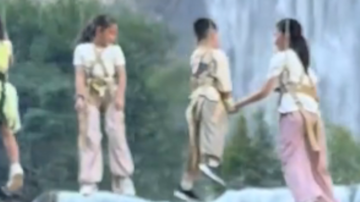 女生瀑布前拍照，空中突然飘来一排人
